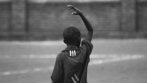 Niño africano con la mano levantada